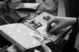 A person browsing an old photo album filled with black and white memories.