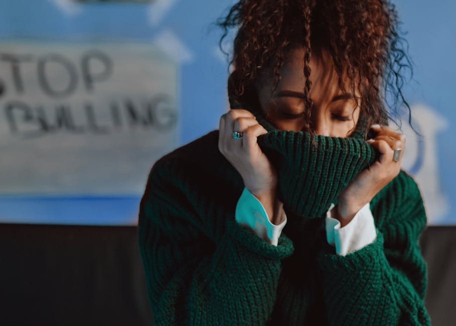 Stylish woman in cozy sweater with anti-bullying sign behind. Inspiring and emotional portrait.