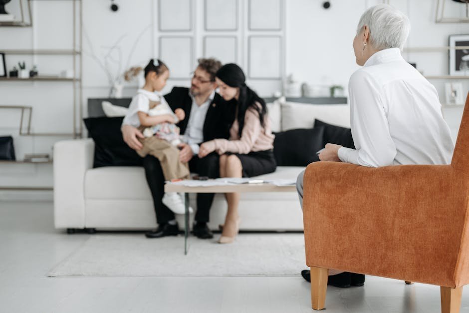 A joyful family adoption meeting with a social worker observing a couple embracing their new child.