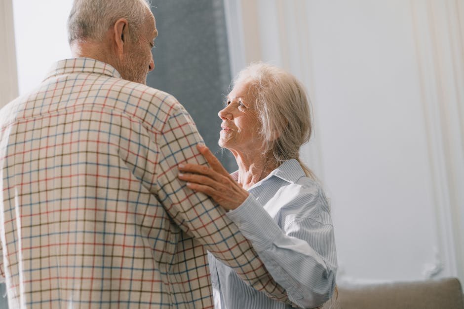 Elderly couple sharing a tender dance indoors, highlighting love and companionship in senior years.