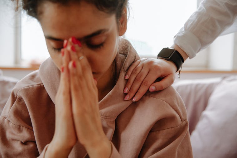 A young woman being comforted with a gentle touch, showing empathy and support.