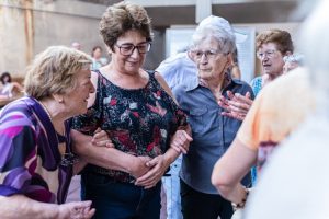 Elderly women enjoying a joyful indoor gathering, sharing smiles and companionship.