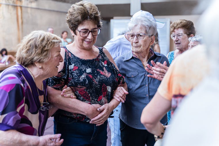 Elderly women enjoying a joyful indoor gathering, sharing smiles and companionship.
